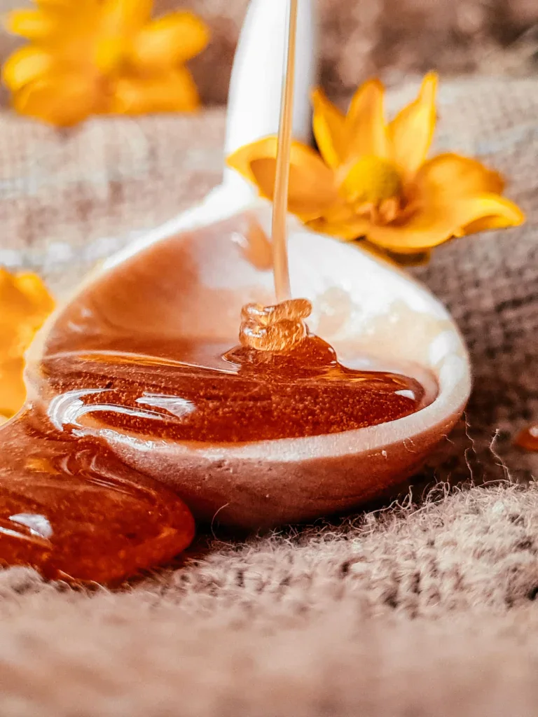 Golden honey dripping from a spoon
