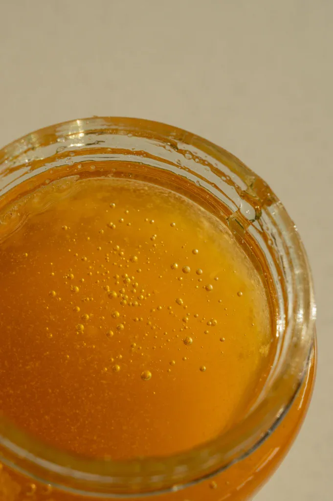golden honey in a jar showcasing its rich amber hue and sticky texture