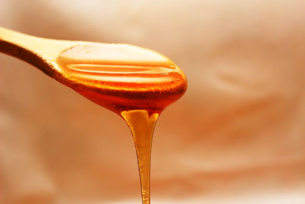 honey dripping from a wooden spoon